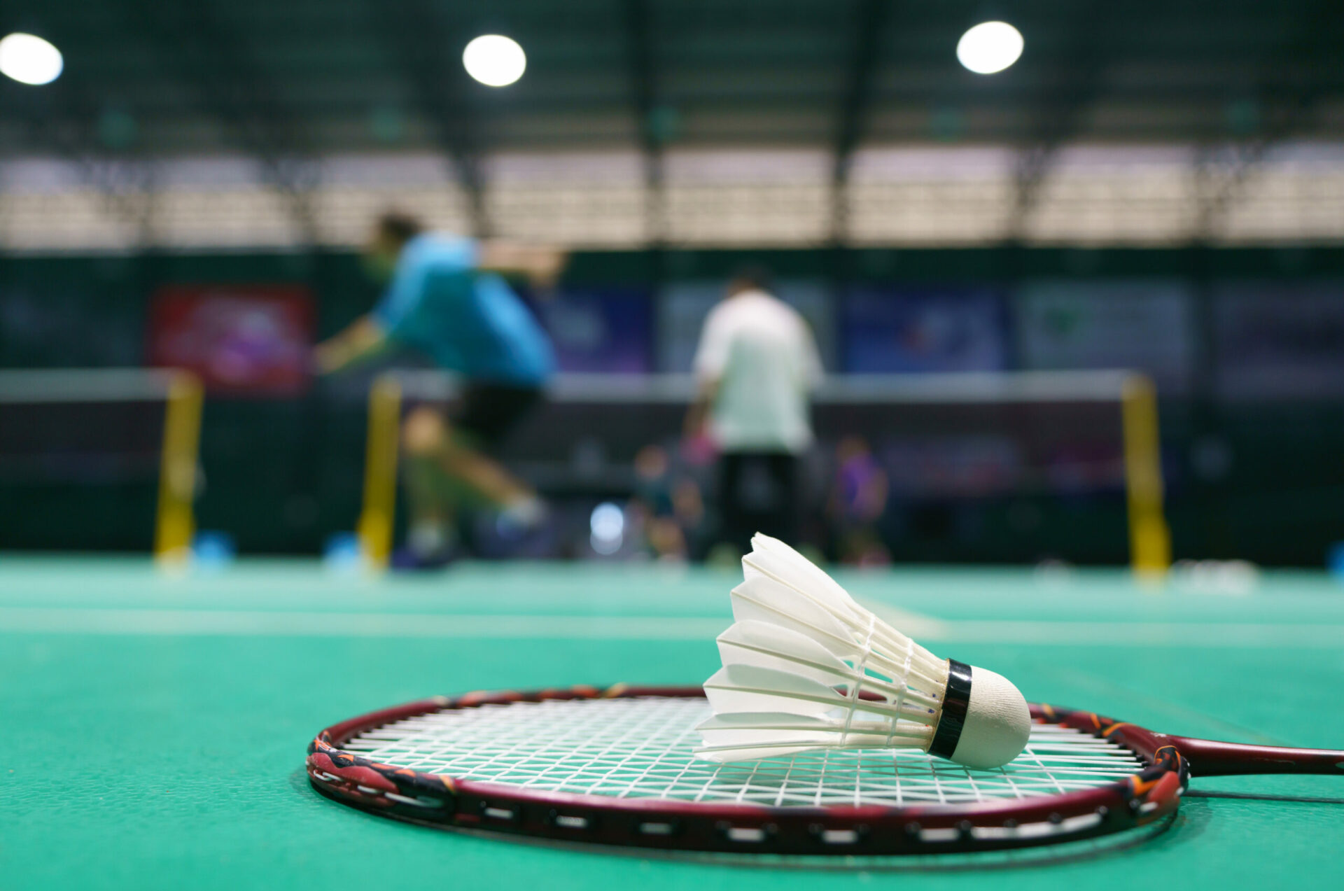 shuttlecock on green badminton playing court 2022 04 08 12 50 00 utc scaled
